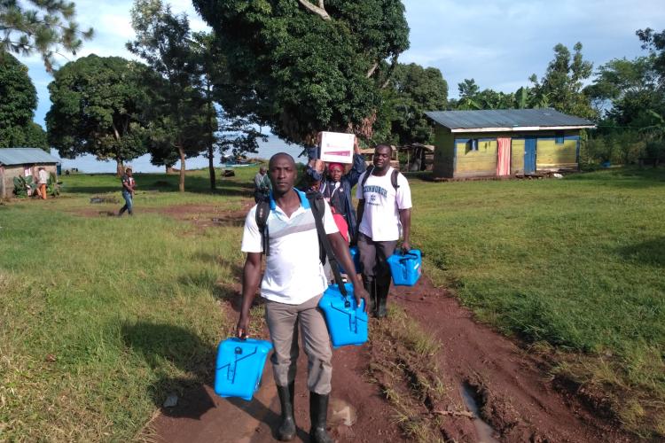 Team carrying Vaccine carriers and credo box on the way to Nanyonyi