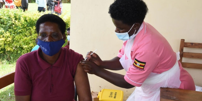 A health worker vaccinating a lady