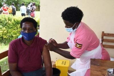 A health worker vaccinating a lady